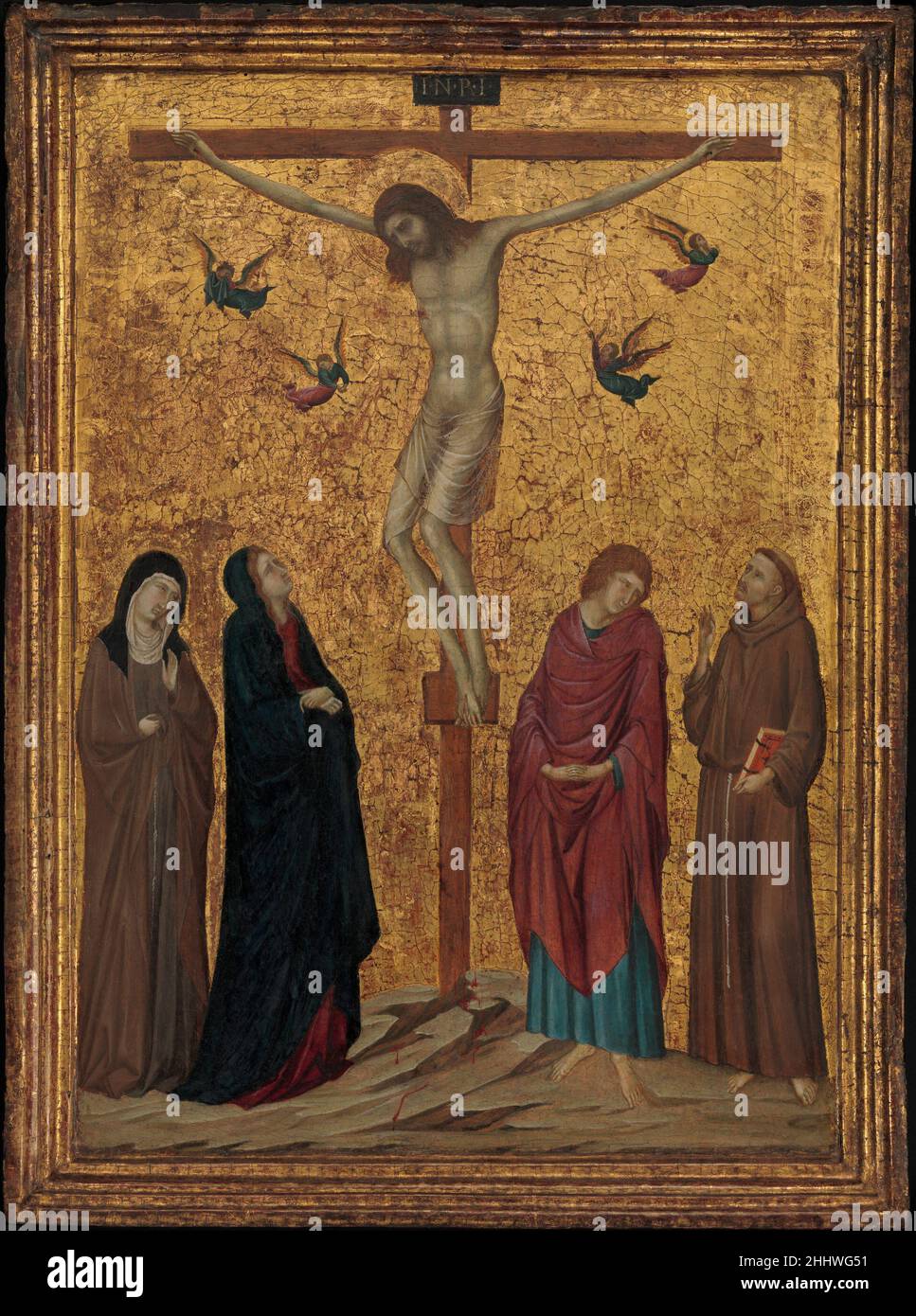 La Crucifixion ca.1315–20 attribué à Ugolino da Siena Italien célèbre à Florence ainsi qu'à Sienne, Ugolino était un proche disciple de Duccio, dont il a dérivé son sens remarquable de la couleur et l'utilisation du geste et de l'expression, créant un effet à la fois lyrique et tragique.La présence des saints François et Clare indique que le panel appartenait à un frère ou une religieuse franciscain, ou peut-être à un membre d'un groupe franciscain laïc.L'or a particulièrement souffert et la tête du Christ est une reconstruction moderne.La Crucifixion 440985 Banque D'Images