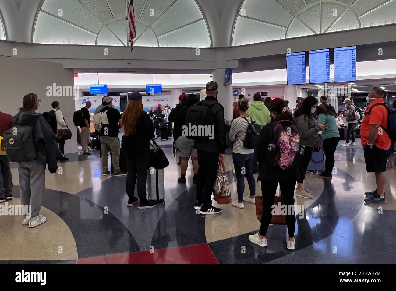 Les passagers regardent le panneau des départs d'American Airlines dans le terminal 4 de l'aéroport international de Los Angeles, le vendredi 21 janvier 2022, à Los Angeles. Banque D'Images