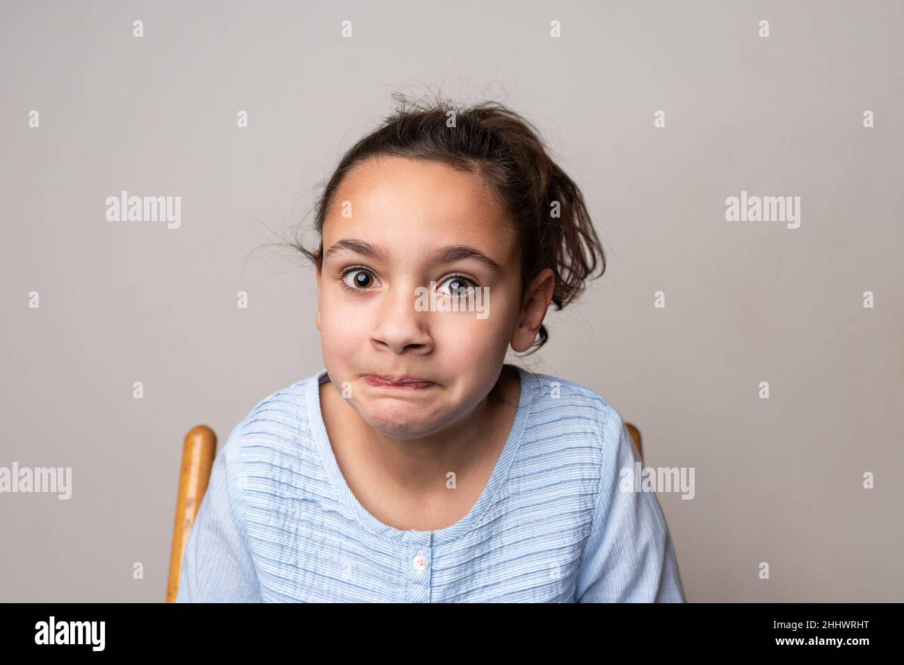 Jeune fille regardant la caméra avec une expression nerveuse sur son visage. Banque D'Images