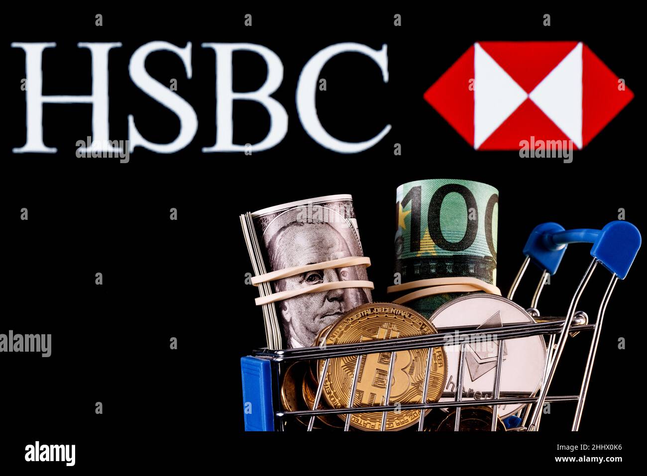 Crypto et devises traditionnelles dans le panier d'achat en arrière-plan du logo de la banque HSBC Banque D'Images
