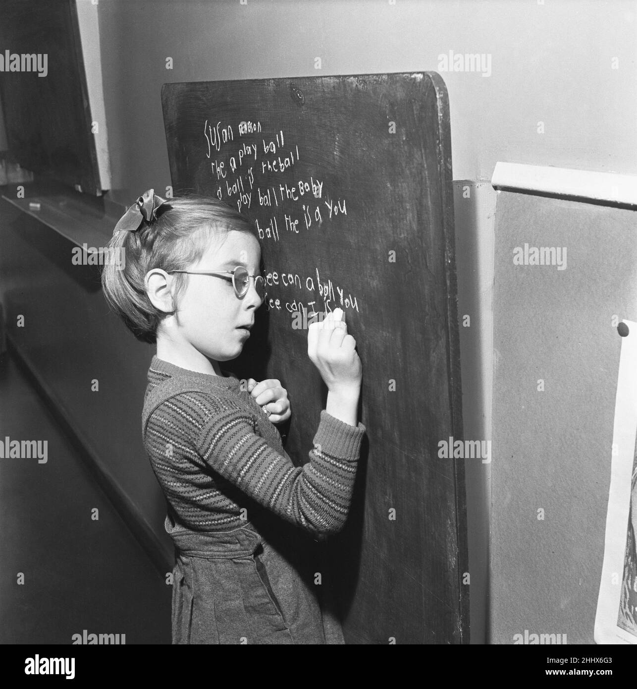 Un des élèves de l'école de South Mead, Southfield, Wimbledon vu ici pratiquer l'écriture à la main sur le tableau noir.14th janvier 1954 Banque D'Images