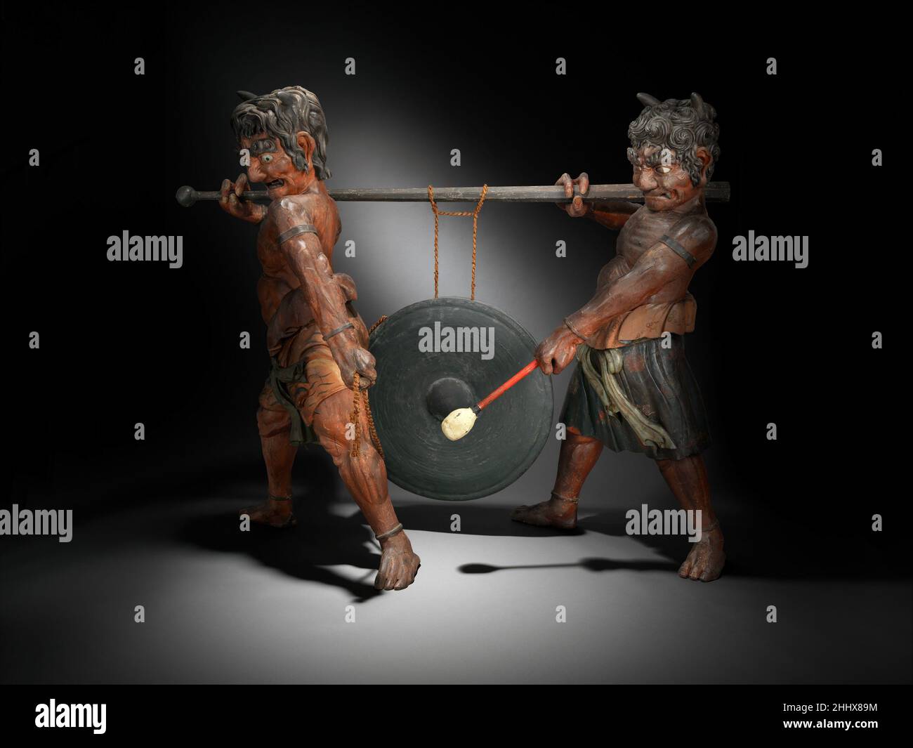 Gong tenu par Oni début 19th siècle japonais cette sculpture féroce a été faite principalement comme pièce d'exposition et peut-être pour attirer le marché européen d'exportation.Les deux oni (démons) portent une grande Dora (gong) dans une procession.Le gong, un exemple authentique, est le type utilisé dans le théâtre, les cérémonies du thé et les rituels bouddhistes.Gong détenu par Oni 502594 Banque D'Images