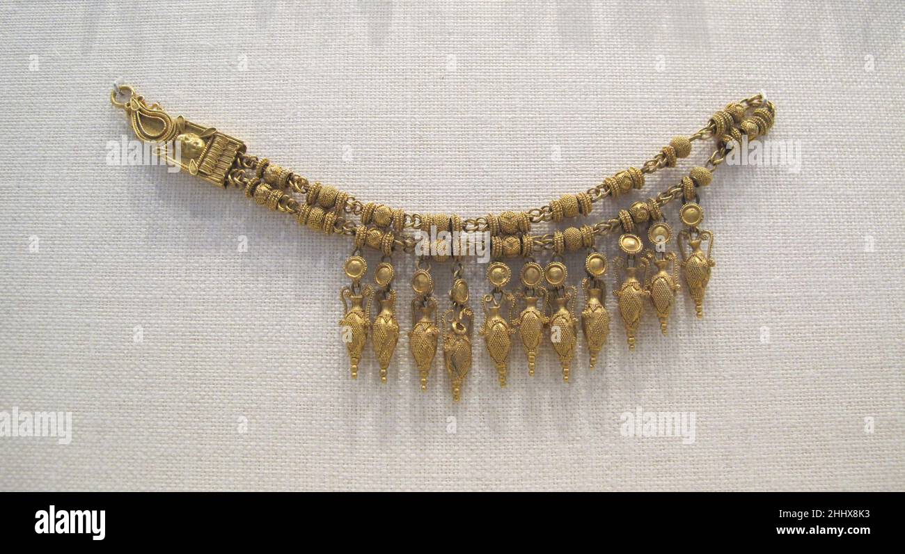 Collier or avec pendentifs d'amphora et perles ca.1840–70 bijoux classiques italiens ou britanniques jouissaient d'une grande popularité à l'époque moderne et inspiraient la production de pièces qui allaient de l'évidemment dérivé à l'franchement trompeur.Des orfèvres du Castellanis en Italie à Tiffany en Amérique ont créé des « bijoux archéologiques » pour une clientèle réceptive.L'exécution était souvent de bonne qualité, comme l'illustre cet exemple.Les pendantes et les granulation en forme d'urne rappellent le travail de Carlo Giuliano (ca.1831-1895)..Collier doré avec pendentif d'amphore et perles.Italien ou britannique Banque D'Images