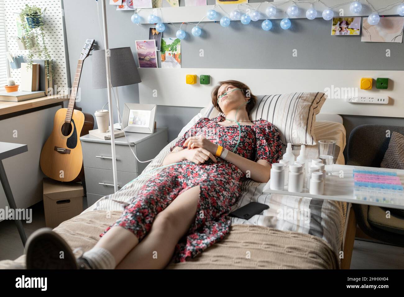 Adolescente tranquille avec un tuyau d'oxygène dans son nez ayant une procédure médicale tout en étant couché sur le lit dans la salle d'hôpital Banque D'Images