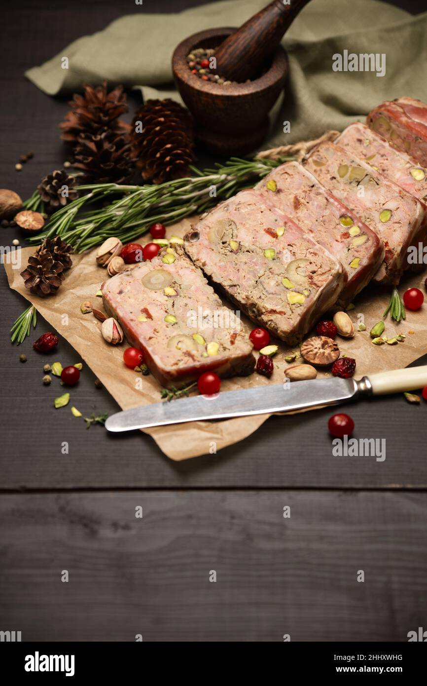 Terrine française traditionnelle en tranches recouverte de bacon sur fond de bois sombre Banque D'Images