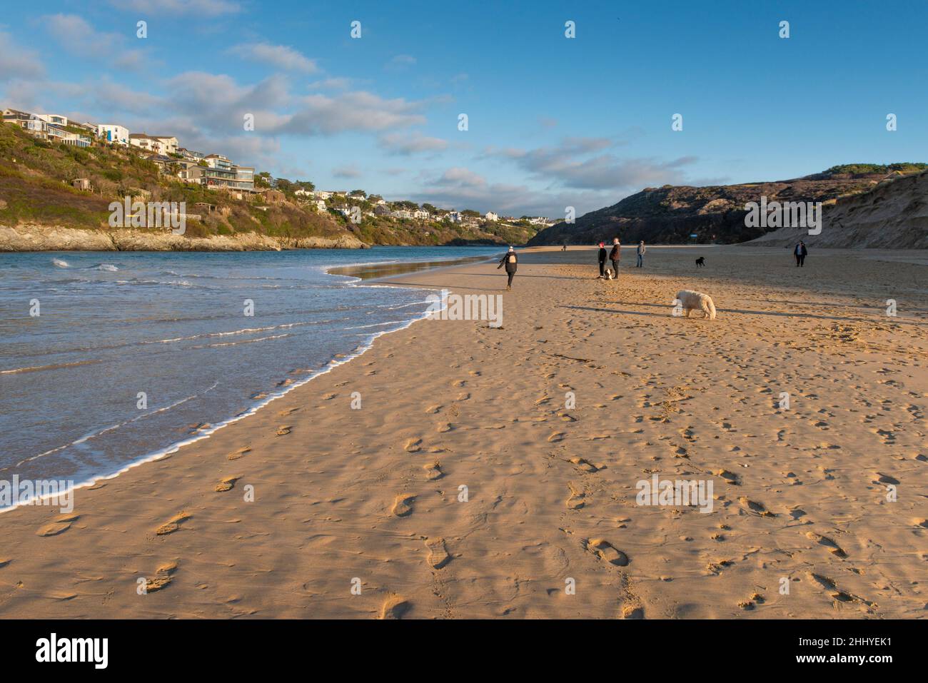Les gens qui marchent leurs chiens et une marée entrante sur la plage primée de Crantock à Newquay, dans les Cornouailles. Banque D'Images