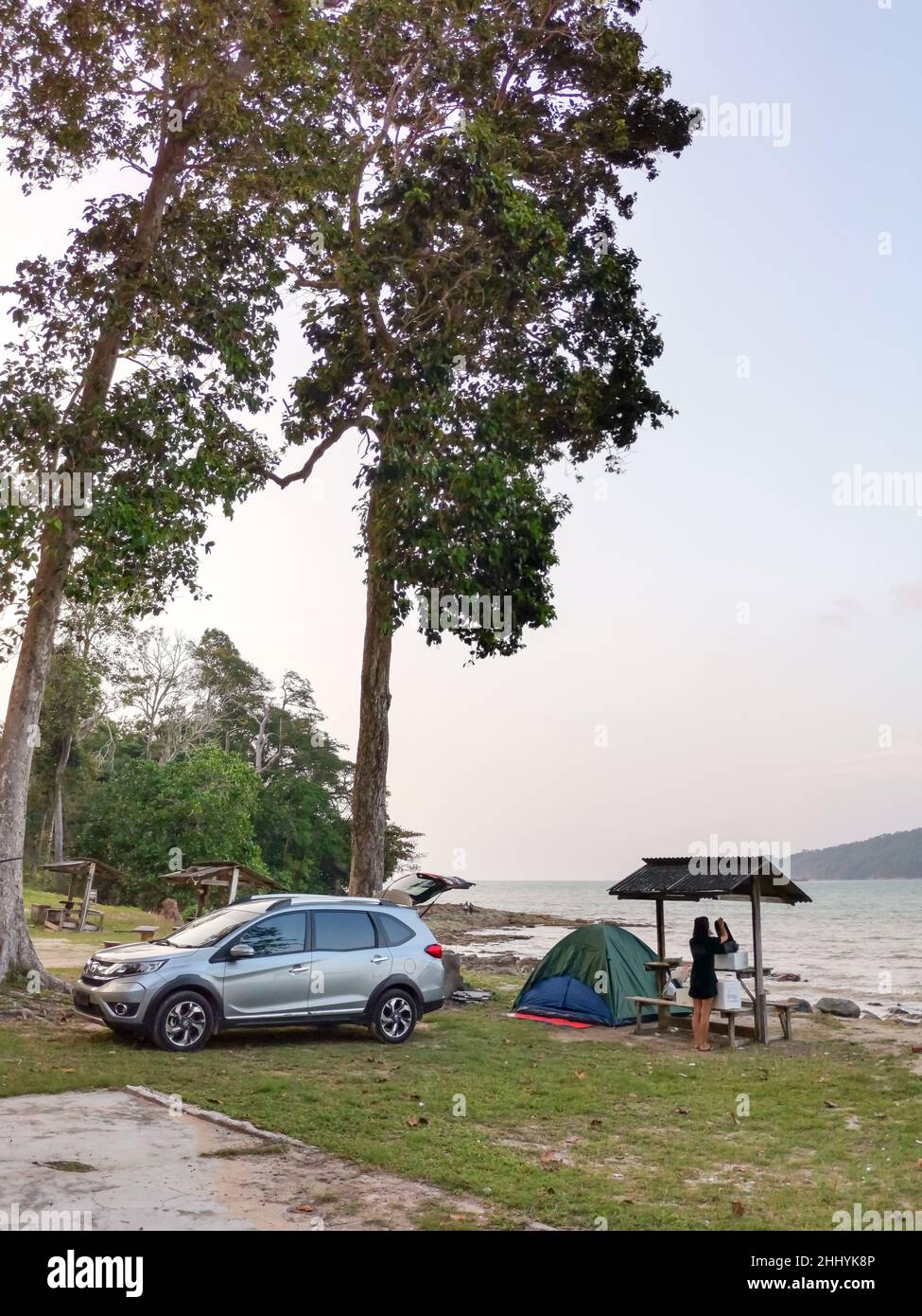 Camping et tente et voiture de sport sous le pin près de la plage de bord de mer avec ciel de coucher de soleil et petite île à l'horizon.Endau, Malaisie Banque D'Images