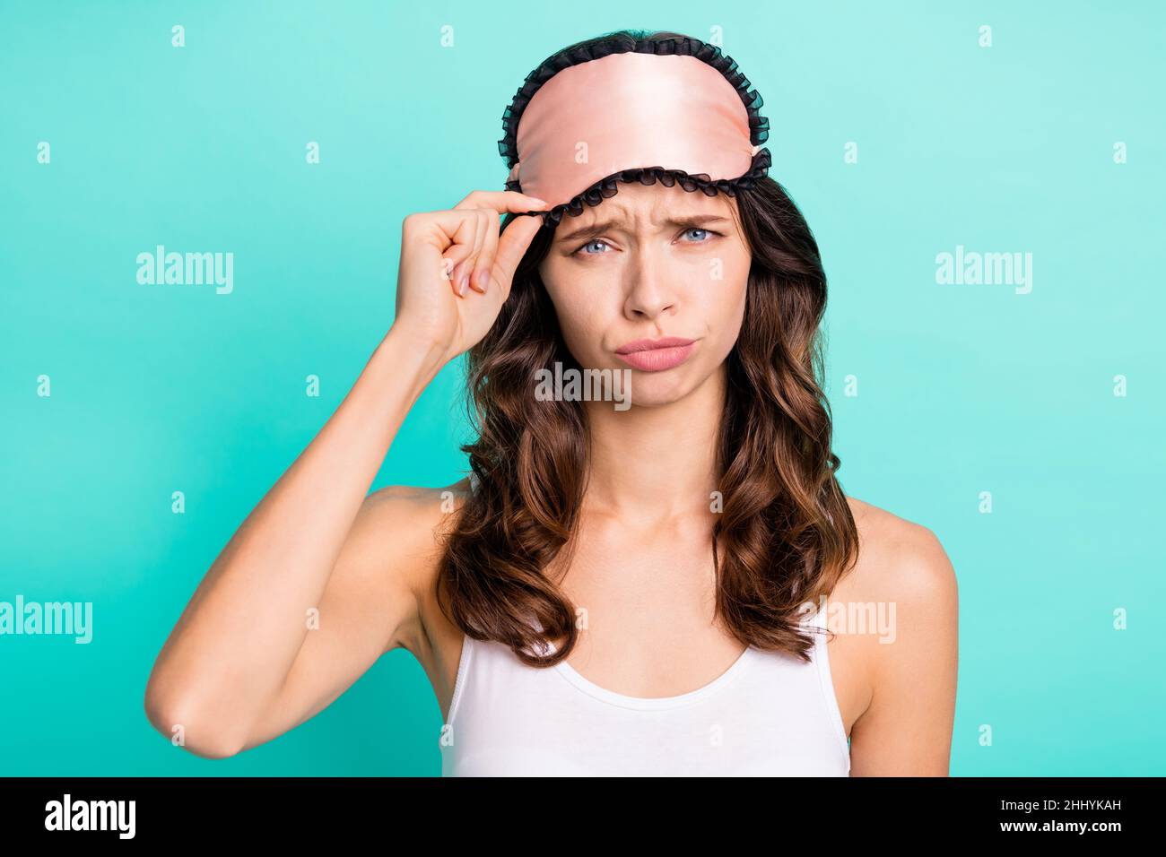 Photo d'une personne attrayante et insatisfaite masque de sommeil de la main au toucher sullen isolé sur fond de couleur sarcelle Banque D'Images