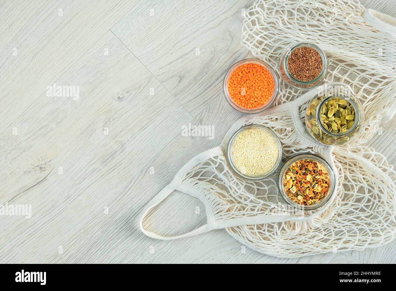 Graines de lin et de citrouille, graines de sésame, lentilles et légumes secs dans des pots en verre sur fond de bois.Les aliments biologiques dans un magasin sans déchets.Copier l'espace.À Banque D'Images