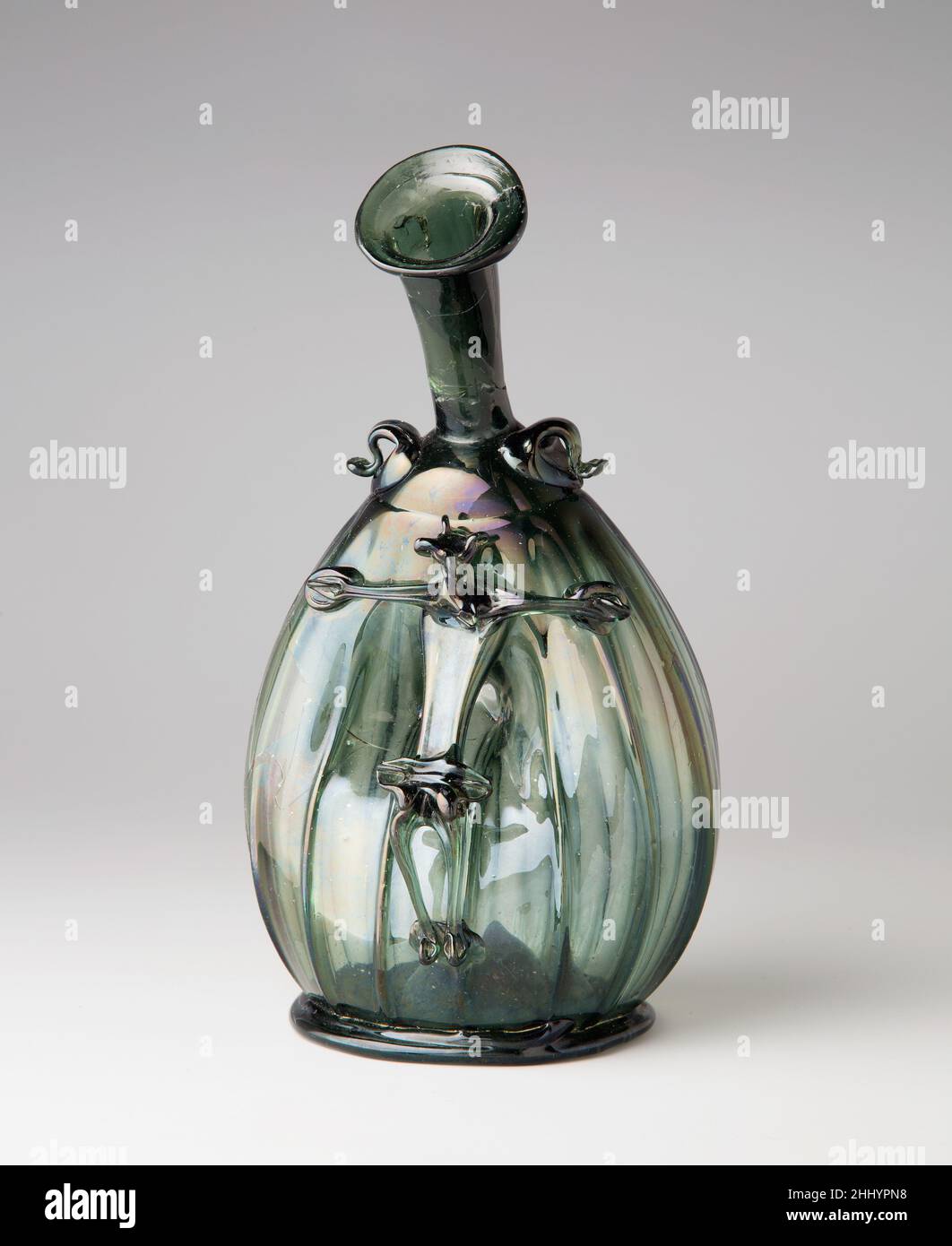 Pilgrim Flask avec le Corpus Christi ca.1490–1510 Allemand ce navire ressemble à une bouteille de pèlerin, avec des boucles sur ses épaules pour la fixation à un cordon ou à une sangle.Exceptionnellement, cependant, une image creuse et libre de Jésus crucifié (Corpus Christi) est attachée à la fiole.Son corps pourrait ainsi être rempli de vin ou de tout autre liquide versé dans la bouteille.La fonction de ce verre inhabituel n'est pas connue.Aurait-il pu être utilisé dans les célébrations de l'église de la Fête de Corpus Christi?.Pilgrim Flask avec le Corpus Christi.Allemand. CA.1490–1510.Verre soufflé avec décoration appliquée.J'ai fait Banque D'Images