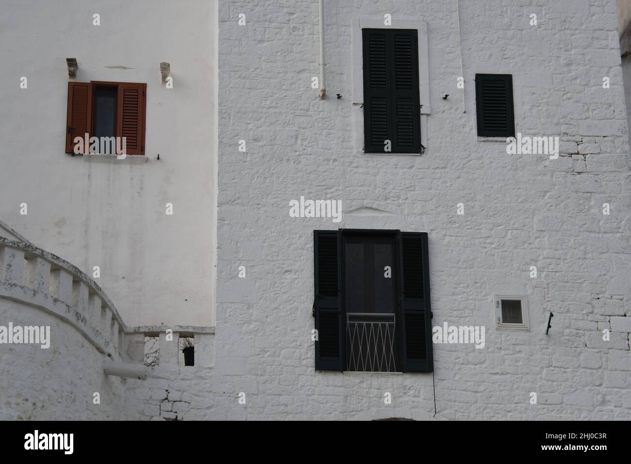 Fenêtres aléatoires sur un mur blanc à l'intérieur de la vieille ville d'Ostuni, également connue sous le nom de 'la ville blanche', Apulia (Italie) Banque D'Images