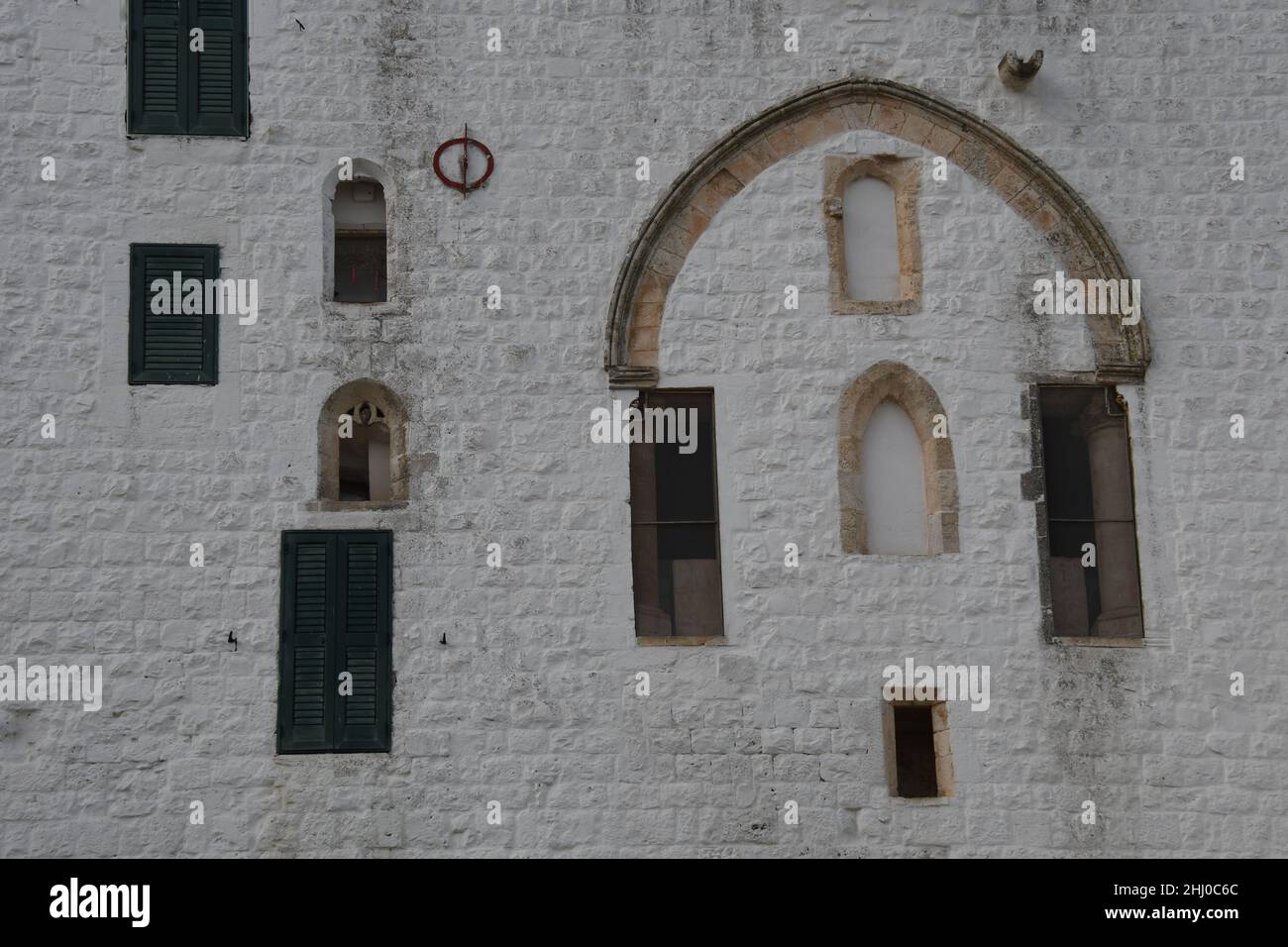Fenêtres aléatoires sur un mur blanc à l'intérieur de la vieille ville d'Ostuni, également connue sous le nom de 'la ville blanche', Apulia (Italie) Banque D'Images