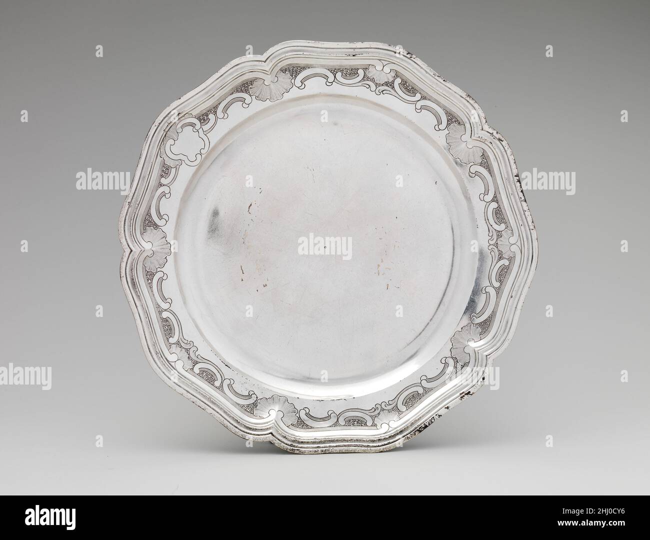 Assiette 1774 Louis Landes les bols couverts comme celui-ci étaient connus en France sous le nom d'ecuelles, et étaient destinés à servir du bouillon chaud ou de la soupe.Le bouillon était généralement servi le matin dans la chambre à coucher pendant les toilettes, le rituel élaboré de lavage et de vinaigrette.Le couvercle du bol a gardé le contenu chaud, et le bouillon peut être sippé du bol en utilisant les deux poignées, tandis que le pain repose sur le support.ce bassin et le support sont décorés avec le plus commun de tous les motifs rococo, les rouleaux sous la forme de la lettre C,et avec des formes abstraites de coquillages et végétales.Les poignées sont constituées d'une bande en boucle Banque D'Images