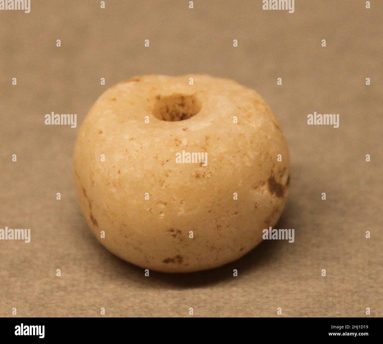 Perle 8th–13th siècle cet objet a été fouillé à Nishapur.Nishapur était une ville vitale au début et au milieu des périodes islamiques, située le long d'une des principales trajectoires qui reliaient l'Iran et les terres islamiques de l'Asie occidentale à l'Asie centrale et à la Chine.Ces itinéraires sont souvent mentionnés par le terme «itinéraires de Silk», mais ont en fait été cruciaux pour le mouvement des constellations de matériaux et d'objets, ainsi que des personnes et des idées.La population diversifiée de Nishapur et de ses environs, des groupes d'élite de marchands mieux étudiés, de l'aristocratie propriétaire de terres et des alphabétisés, à l'arti moins connu Banque D'Images