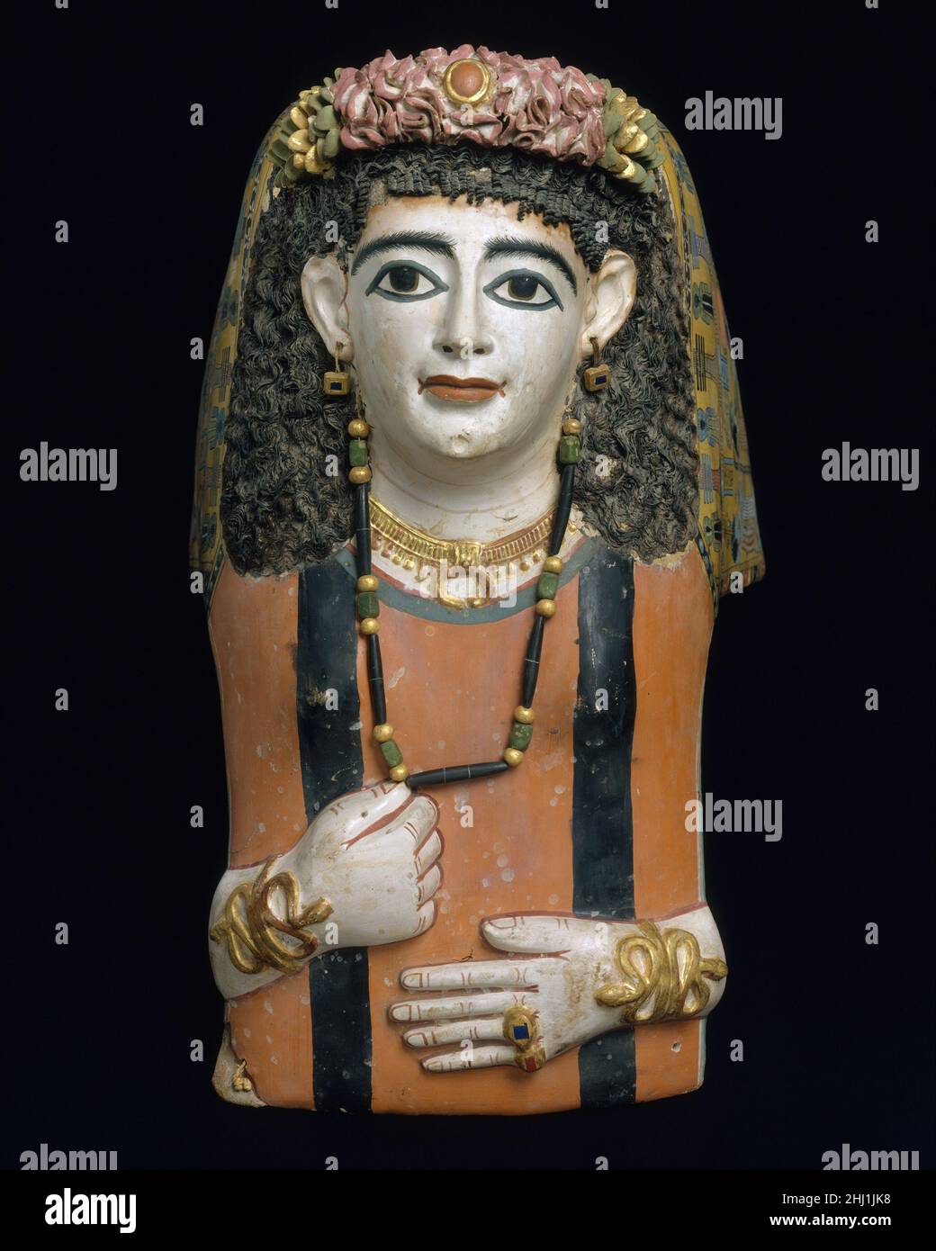 Masque de momie A.D. 60–70 période romaine les masques de plâtre semblent avoir été particulièrement populaires au Moyen-Égypte.Ils se développent bien sûr à partir de traditiions égyptiens, mais les apparences pourraient être fortement individualisées et les modes romains de coiffure, de robe et de bijoux ont été suivis à des degrés divers.Ce masque est très semblable à un groupe de Meir et est presque certainement venu de cet emplacement.La femme est représentée comme si elle était à plat sur son bier.Elle porte une longue perruque de style égyptien faite de fibres végétales, une tunique rouge foncé avec un clavi noir (rayures), et des bijoux qui comprennent une lunula (pendentif croissant), et sna Banque D'Images