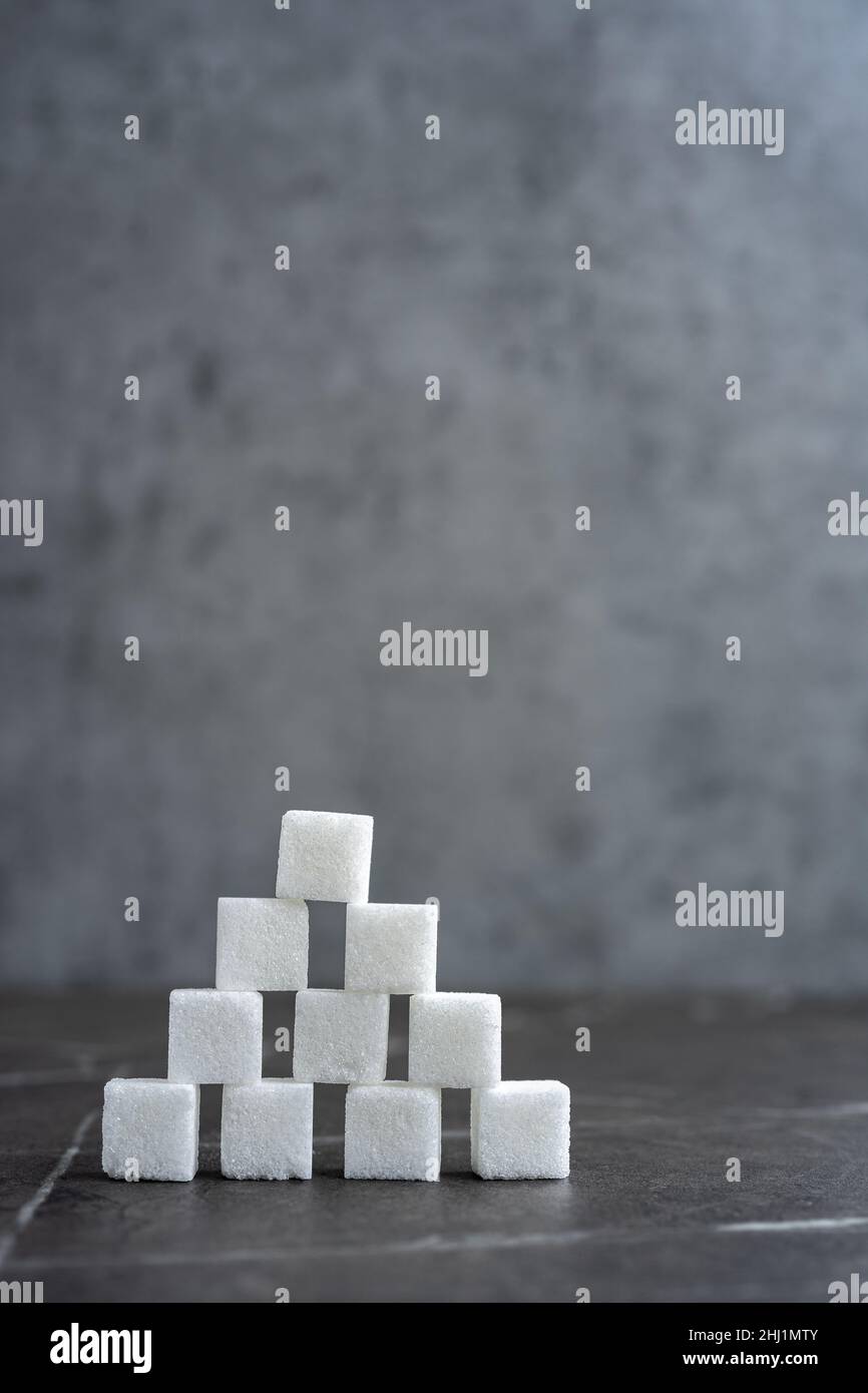 Pyramide de cubes de sucre sur fond gris Banque D'Images