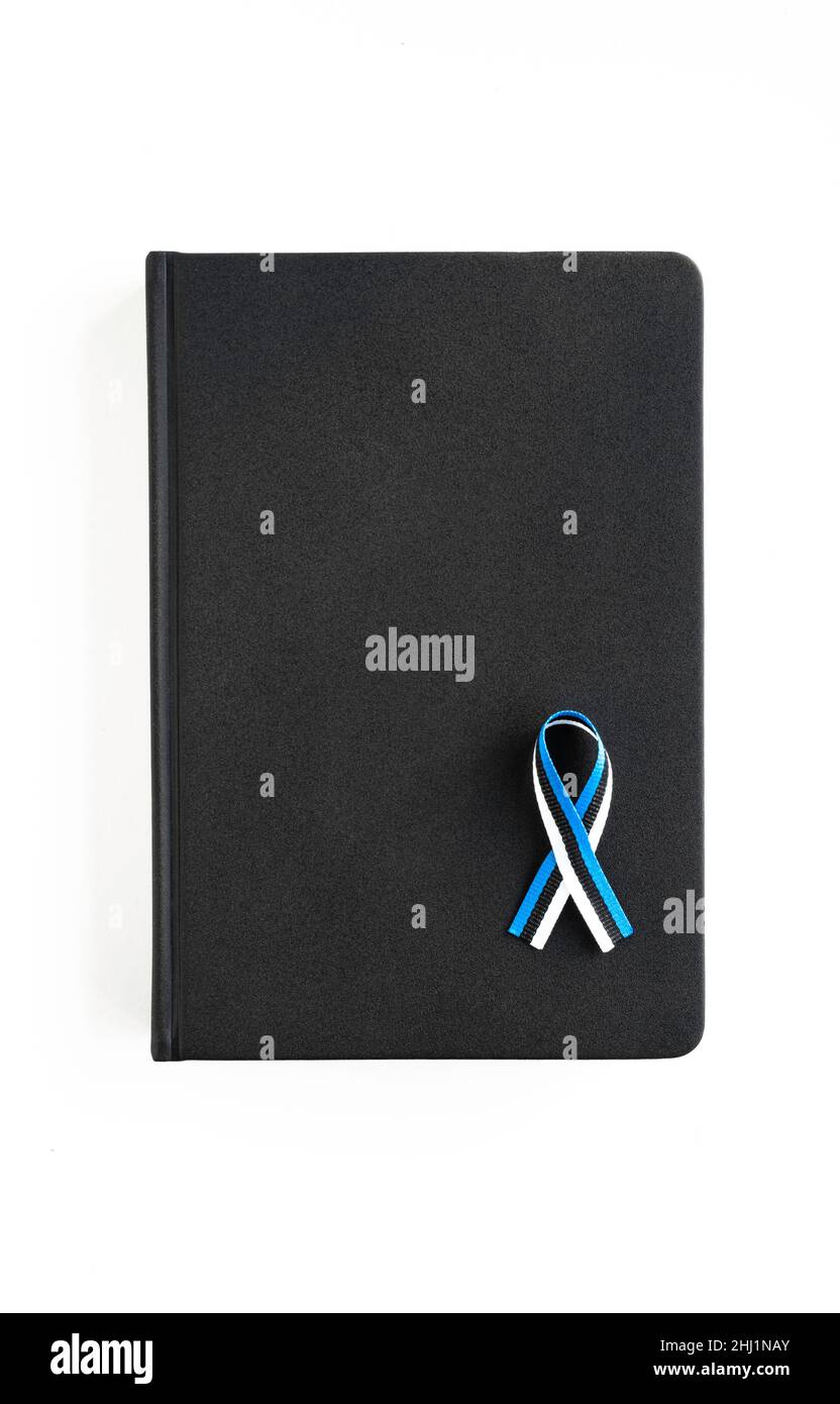 Livre noir avec ruban aux couleurs du drapeau estonien, isolé sur fond blanc Banque D'Images