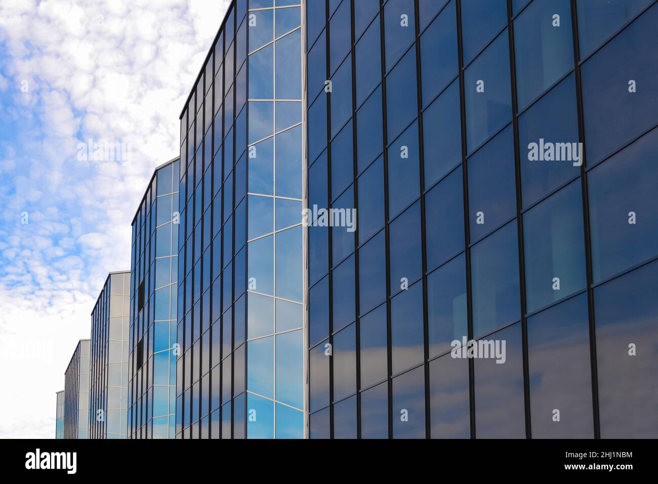 Un bâtiment en verre contre un ciel bleu et des nuages Banque D'Images