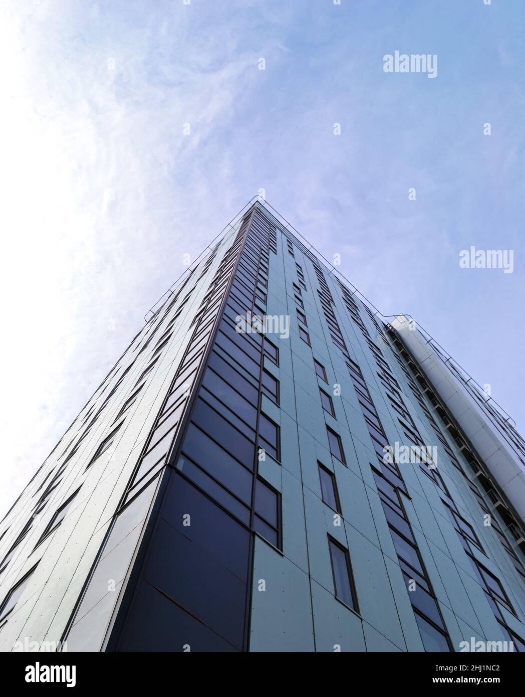 Coin d'un immeuble de bureaux contre un ciel bleu et des nuages Banque D'Images