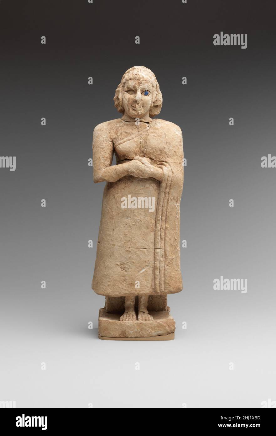 Femme adoratrice debout ca.2600–2500 C.-B. sumérien cette statue d'une femme debout, avec ses mains accrochée devant sa poitrine, a été trouvée dans les plâtres d'un banc en brique de boue situé dans l'une des cellules du temple de Nippur d'Inanna (niveau VIIIB), déesse sumérienne d'abondance.Son vêtement est drapé sur son épaule gauche et tombe dans des plis indiqués par deux lignes incisées le long de la bordure du tissu autrement lisse.Les pieds sont sculptés en relief élevé contre le support arrière et les orteils et les chevilles sont clairement indiqués.Les cheveux ondulés sont maintenus en place par deux bandes simples, et curl Banque D'Images