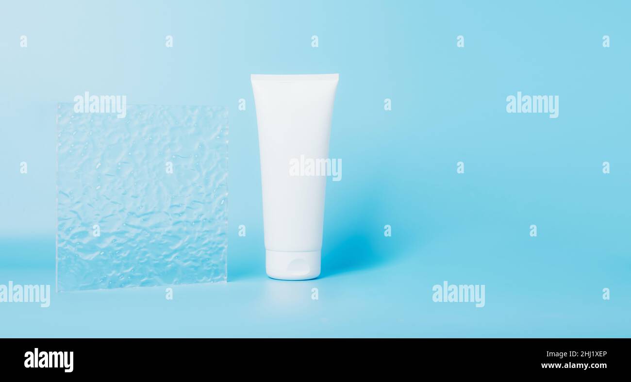 Produit cosmétique dans un tube, contenant blanc sur fond bleu.Shampooing, crème pour les mains, dentifrice emballage blanc Banque D'Images