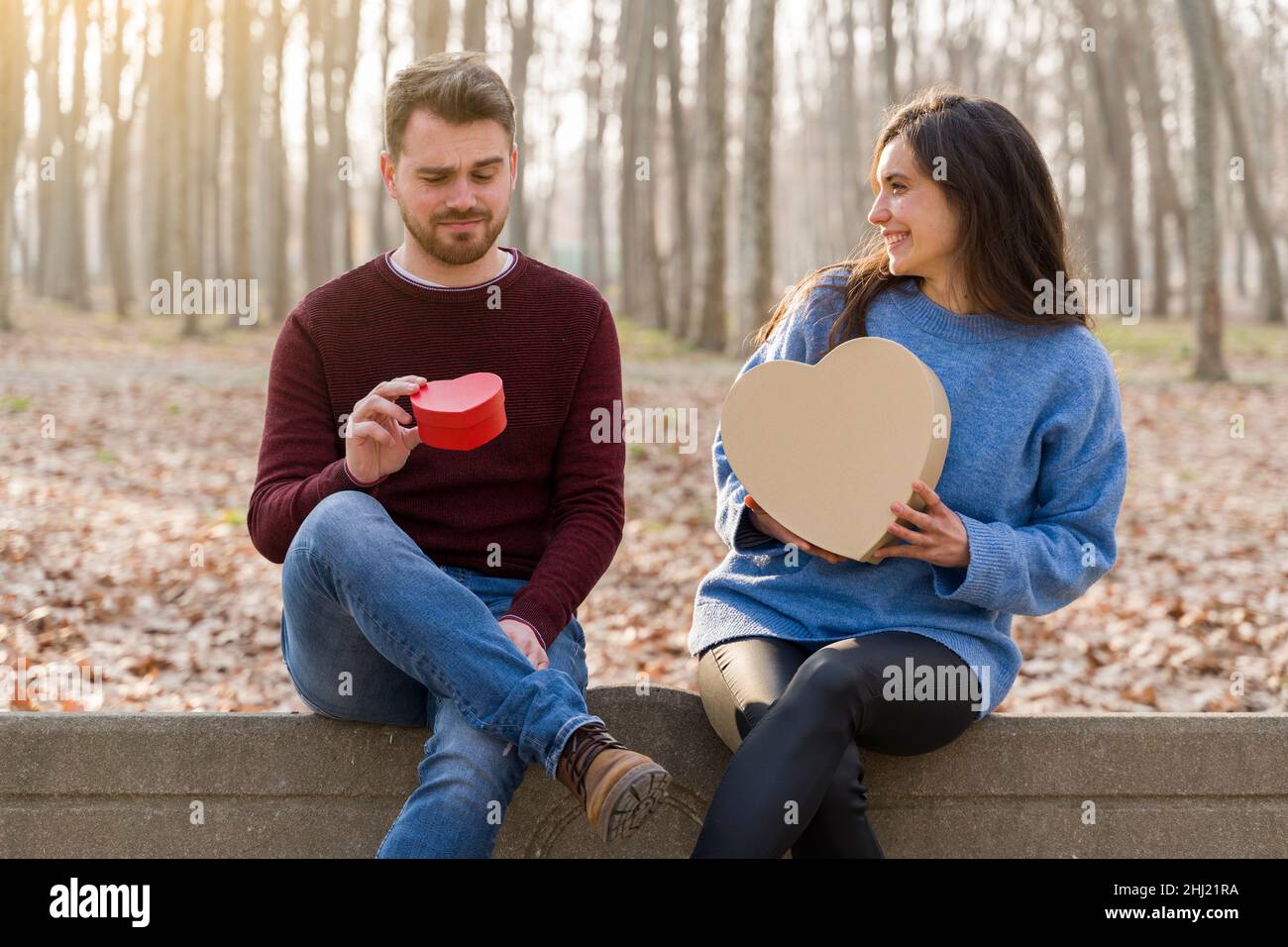 Jeune couple célébrant la Saint-Valentin en faisant un cadeau dans un parc Banque D'Images