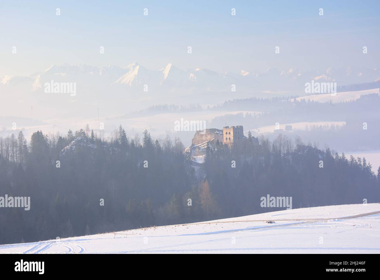 Pieniny en hiver.Vue sur les ruines du château médiéval de Czorsztyn.Un panorama des montagnes Tatra au loin. Banque D'Images