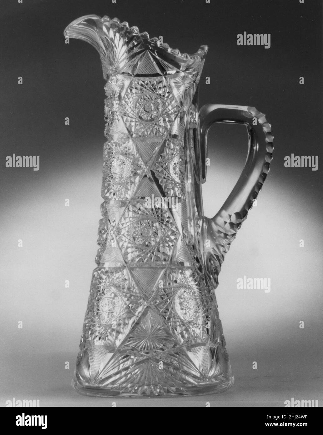 Pitcher 1890 Dorflinger Glass Works les usines de verre fondées par l'émigré alsacien Christian Dorflinger ont sans doute été parmi les plus importantes usines de verre en opération du milieu à la fin du XIXe siècle.Sa première usine était à Brooklyn, New York, d'où il a déménagé ses opérations à White Mills, en Pennsylvanie, où cet objet a été fabriqué.Ce pichet cylindrique aux conceptions finement coupées représente la qualité du verre et la découpe accomplie pour lesquelles ils ont été renommés.Il est descendu dans la famille de Christian Dorflinger.Pichet 5788 Banque D'Images
