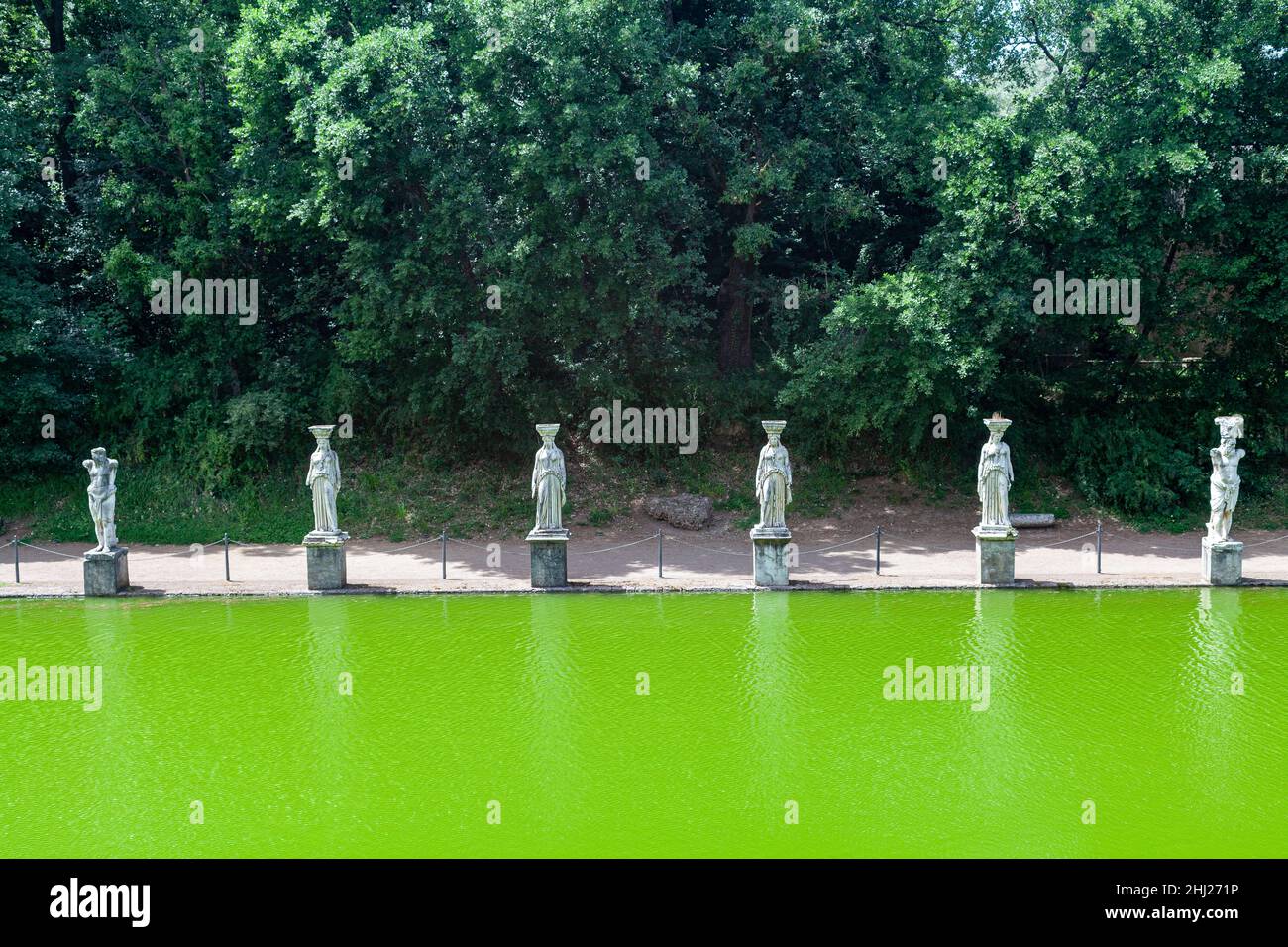 L'eau verte d'une ancienne piscine entourée de statues romaines dans le parc archéologique de Villa Adriana, Latium Banque D'Images