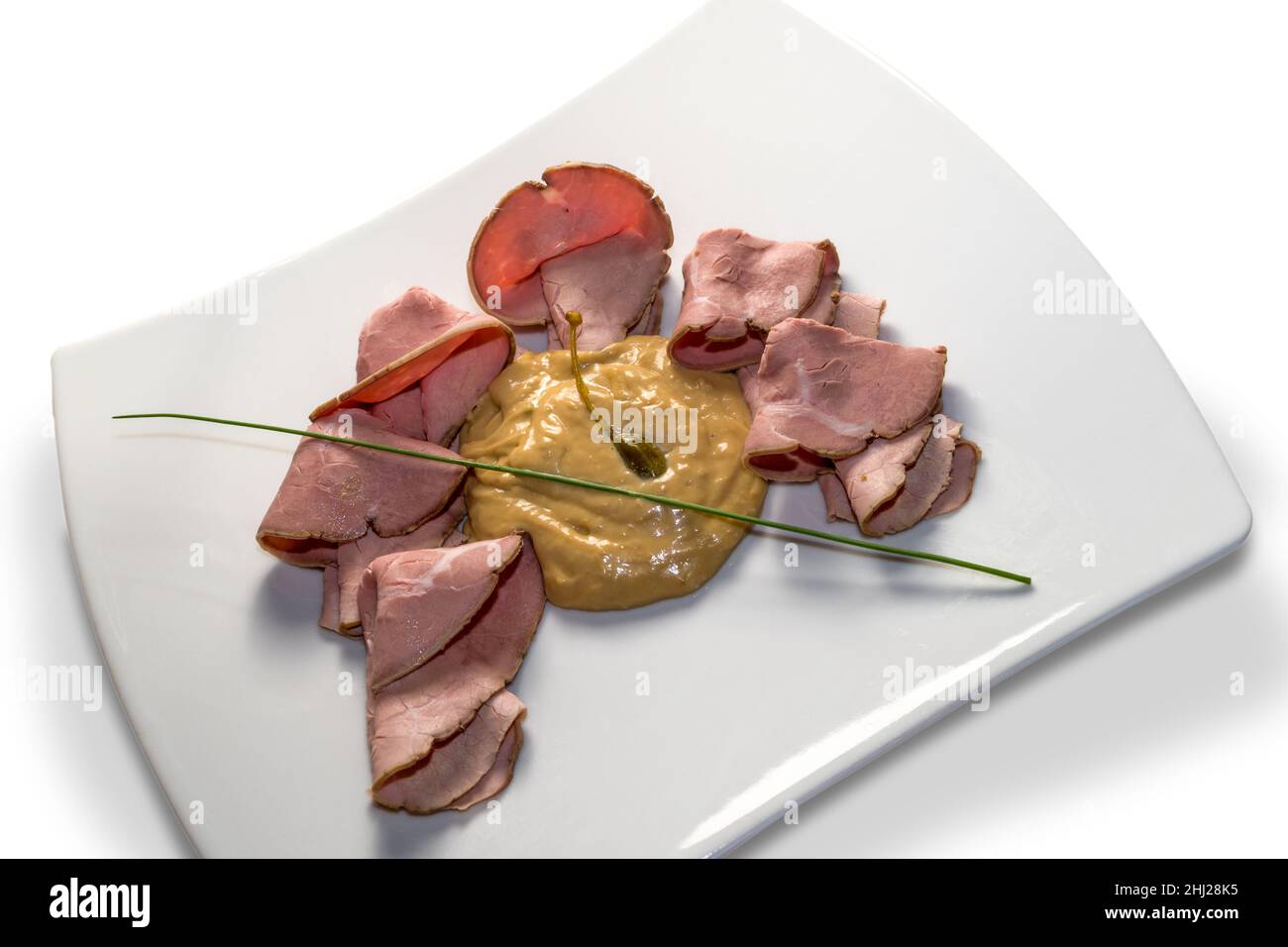 Vitello tonnato, rôti de bœuf italien typique du Piémont avec câpres marinées, tranches de veau, sauce mayonnaise avec thon dans un plat blanc isolé sur blanc Banque D'Images