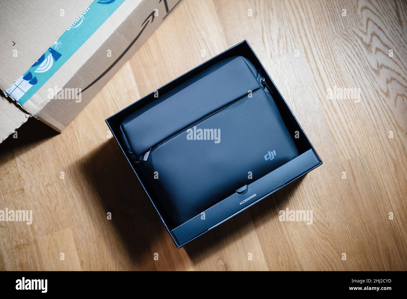 Paris, France - 14 janvier 2022: POV main mâle tenant le papier noir de luxe avec le logotype DJI après avoir déballer un nouveau drone sac à bandoulière.DJI est une société de technologie chinoise dont le siège est situé à Shenzhen, Guangdong, Banque D'Images