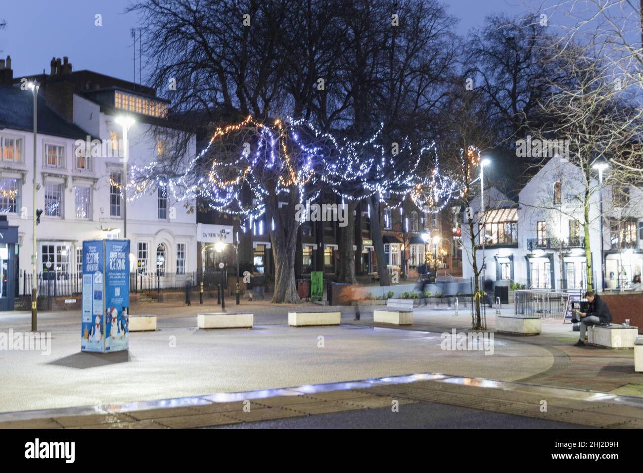 Nouvelle place de marche, montre une photo de nuit avec des lumières de Noël lumineuses, place ouverte avec des meubles de rue, des marches, et des bâtiments et des arbres en arrière-plan. Banque D'Images