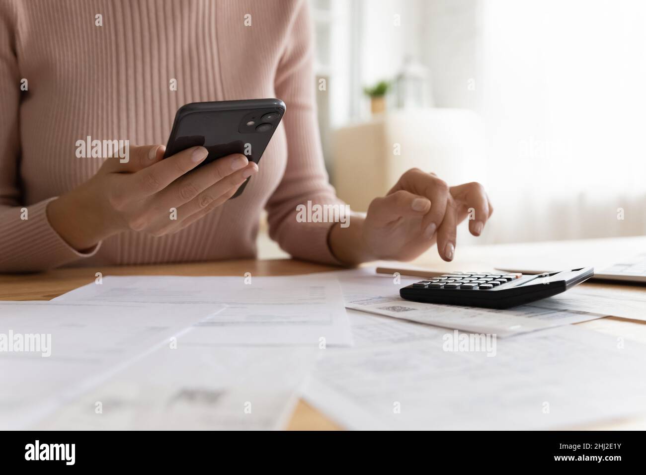 Woman effectue des calculs et paie des factures via l'application e-Bank sur smartphone Banque D'Images