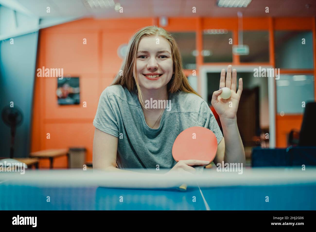 Portrait d'une jeune fille souriante de tennis de table avec une raquette de ping-pong.Main onduleuse Banque D'Images