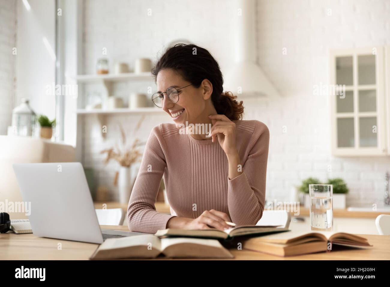 Femme e-learning utilisant le tas d'ordinateur des manuels sur la table Banque D'Images
