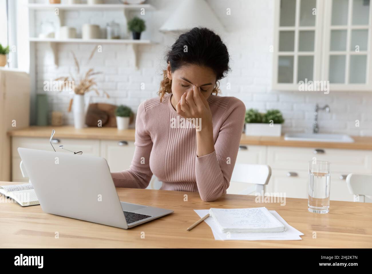 Une femme prend ses lunettes après une longue utilisation de l'ordinateur Banque D'Images