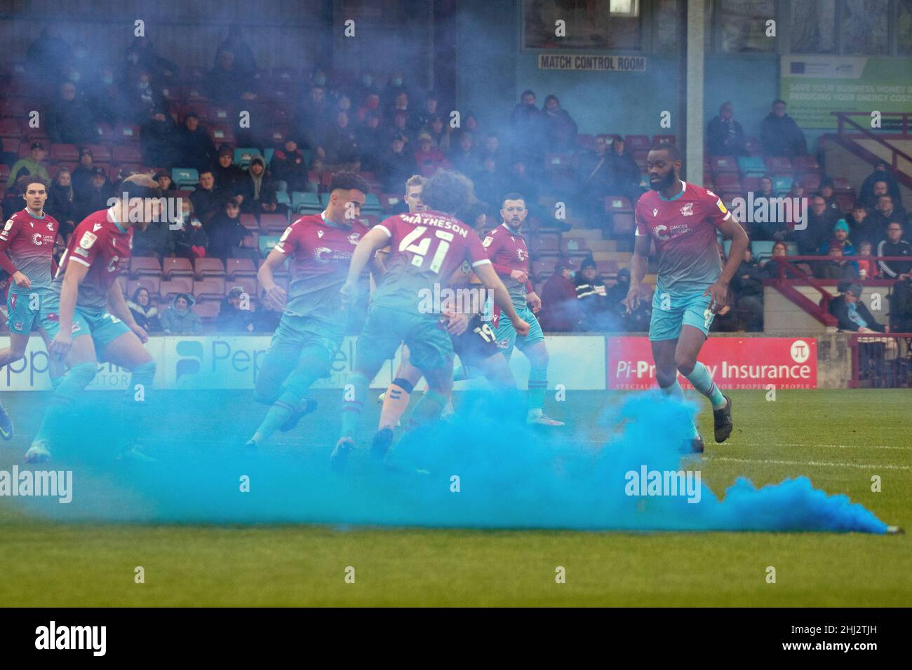 Le jeu se poursuit alors qu'une explosion bleue/bombe de fumée est lancée sur le terrain pendant le jeu.EFL Skybet football League Two Match, Scunthorpe Utd / Newport Coun Banque D'Images