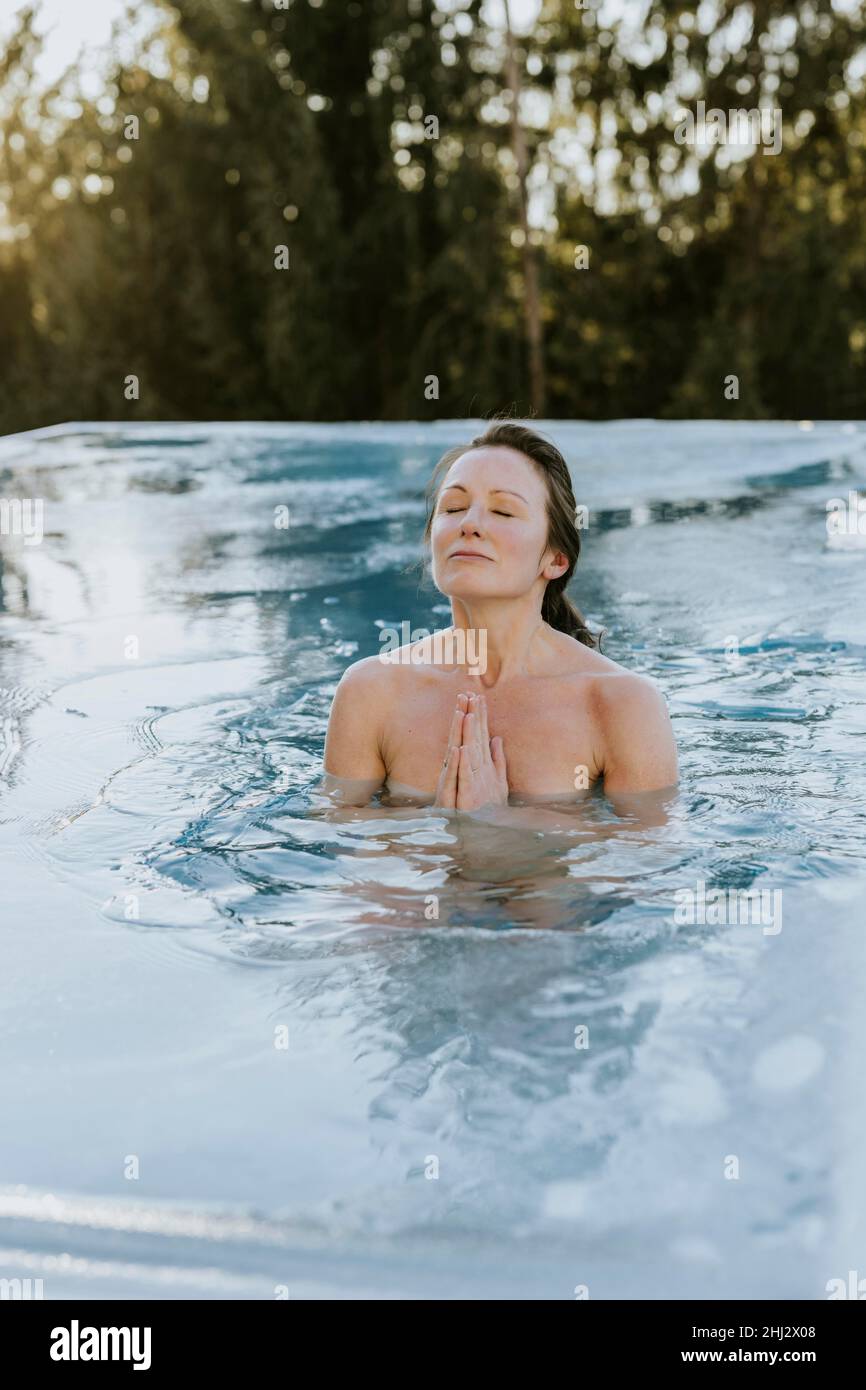 Femme se plie les mains pendant qu'elle se baignait dans la piscine Banque D'Images