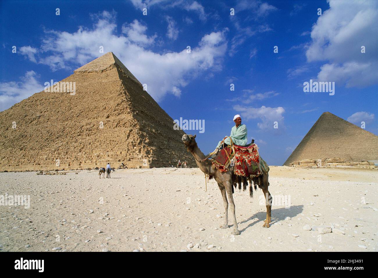 Homme à cheval sur un Camel devant les pyramides de Gizeh, Gizeh, Égypte Banque D'Images