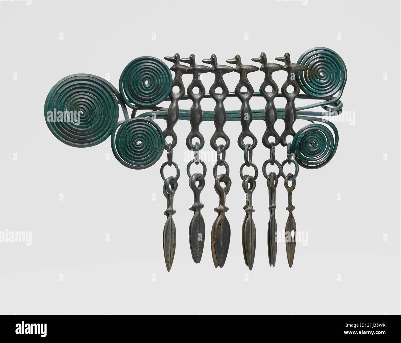 Grande broche 1100–1000 BC âge européen du bronze cette broche est l'un des objets les plus grands et les plus complexes de son type pour survivre à partir de l'Europe de l'âge du bronze tardif.Les cinq spirales dynamiques étaient composées de trois longs fils.Six éléments composites sont suspendus de la section horizontale : en haut de chacun se trouve un oiseau surmontant un morceau de cheval, sous lequel se trouvent des anneaux et des paires de lames de poignard.Les nombreuses arches contenant de tels objets suggèrent qu'elles fonctionnaient comme offrandes rituelles déposées pendant les inhumations.la broche est l'un d'un groupe de onze objets (sept autres broches et deux bracelets) donnés à t Banque D'Images