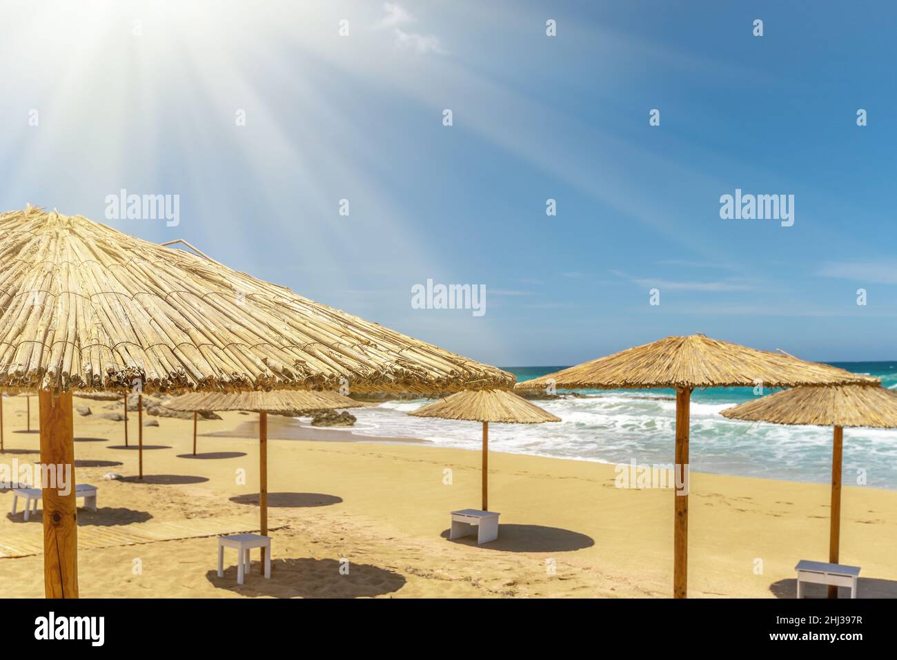 Plage de sable vide avec parasols en été avec lumière du soleil. Banque D'Images