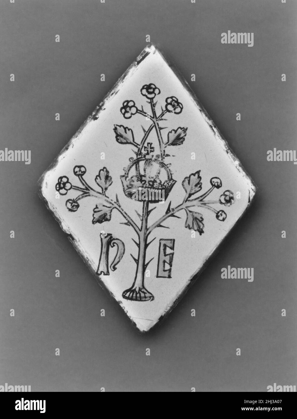 Carrière (une de deux) début du 16th siècle britannique, éventuellement Surrey au XVe siècle, les « carrières » en forme de diamant (éventuellement du carré français, pour la place) sont devenues populaires dans les environnements domestiques et de bureau.Ces petits panneaux étaient souvent ornés de motifs héraldiques et placés dans une plus grande conception de vitraux.Cette paire présente l'un des nombreux insignes royaux du roi anglais, Henry VII: Une branche couronnée et épineuse d'aubépine, flanquée des initiales 'H' et 'E' pour Henry et sa reine, Elizabeth de York.Selon la légende, le Tudor Henry VII trouva la couronne royale dans un ha Banque D'Images