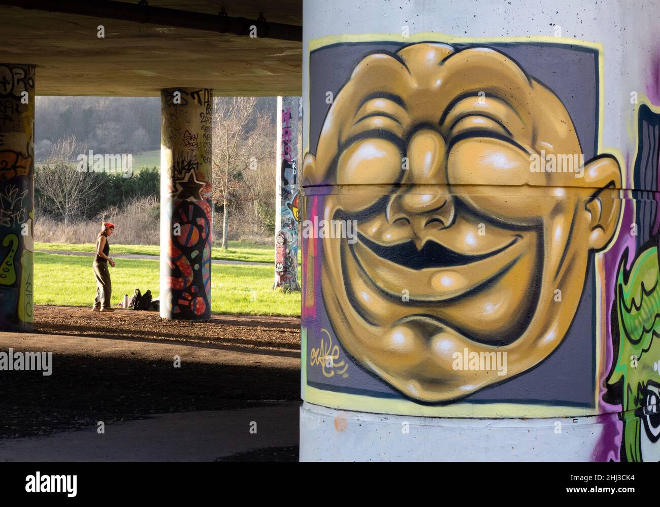 Artiste graffiti travaillant sous le réseau routier du bassin de Cumberland à Bristol, Royaume-Uni Banque D'Images