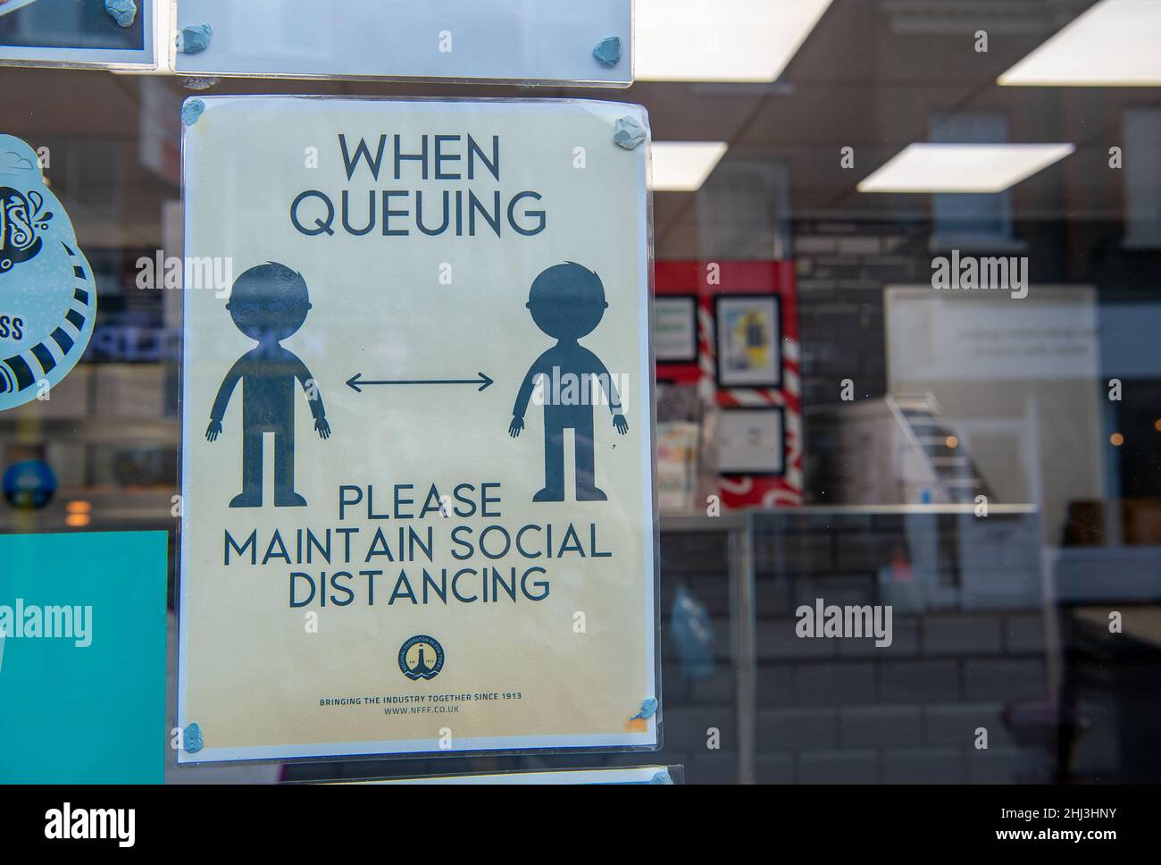 Chertsey, Surrey, Royaume-Uni.26th janvier 2022.Un signe de distance sociale dans une fenêtre de magasin.Les mesures Covid-19 sont levées en Angleterre à partir de demain 27th janvier 2022, bien que certains magasins prévoient toujours de demander aux gens de porter des masques pour aider à arrêter la propagation de la variante Covid-19 Omicron.Crédit : Maureen McLean/Alay Banque D'Images