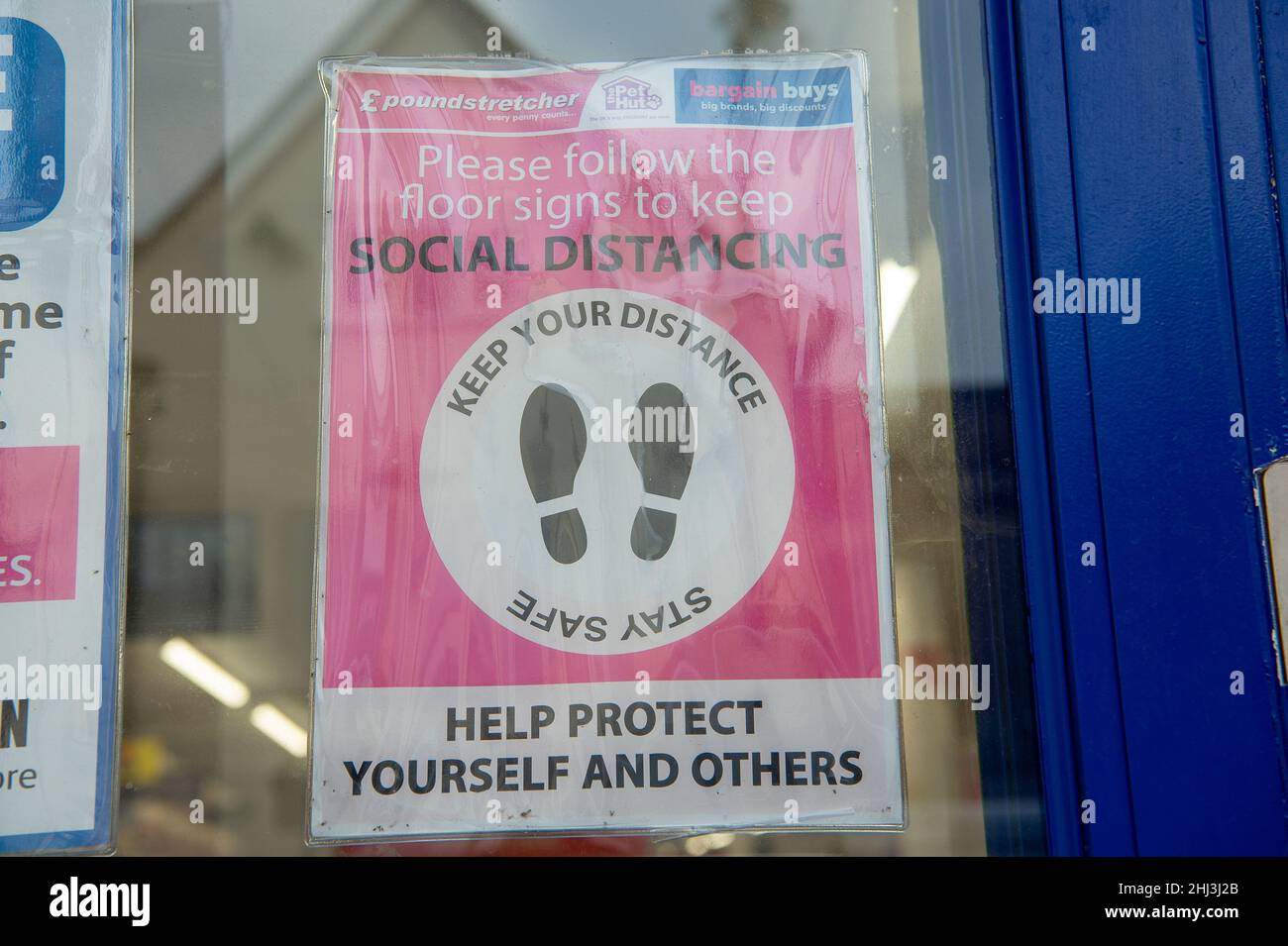 Chertsey, Surrey, Royaume-Uni.26th janvier 2022.Un signe social de distanciation dans la fenêtre de Poundbrancher.Les mesures Covid-19 sont levées en Angleterre à partir de demain 27th janvier 2022, bien que certains magasins prévoient toujours de demander aux gens de porter des masques pour aider à arrêter la propagation de la variante Covid-19 Omicron.Crédit : Maureen McLean/Alay Banque D'Images