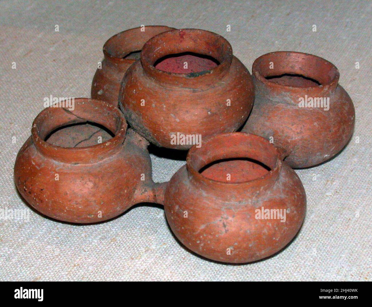 Jars de Pigment groupés A.D. 300–800 Teotihuacan ce navire est originaire de Teotihuacan, un important développement urbain et une culture complexe située dans le centre du Mexique.Le travail intègre cinq pots en céramique globulaire, dont quatre positionnés en périphérie pour former une empreinte carrée, le cinquième centré et planant légèrement au-dessus de ses homologues.Ensemble, les bocaux forment une forme à cinq lobes connue sous le nom de quincunx, symbole d'une grande importance cosmologique pour les religions méso-américaines.Des traces de pigment enrobent les intérieurs de chacun des bocaux, révélant l’utilisation du navire comme palette de peintre.Ces pigments Banque D'Images