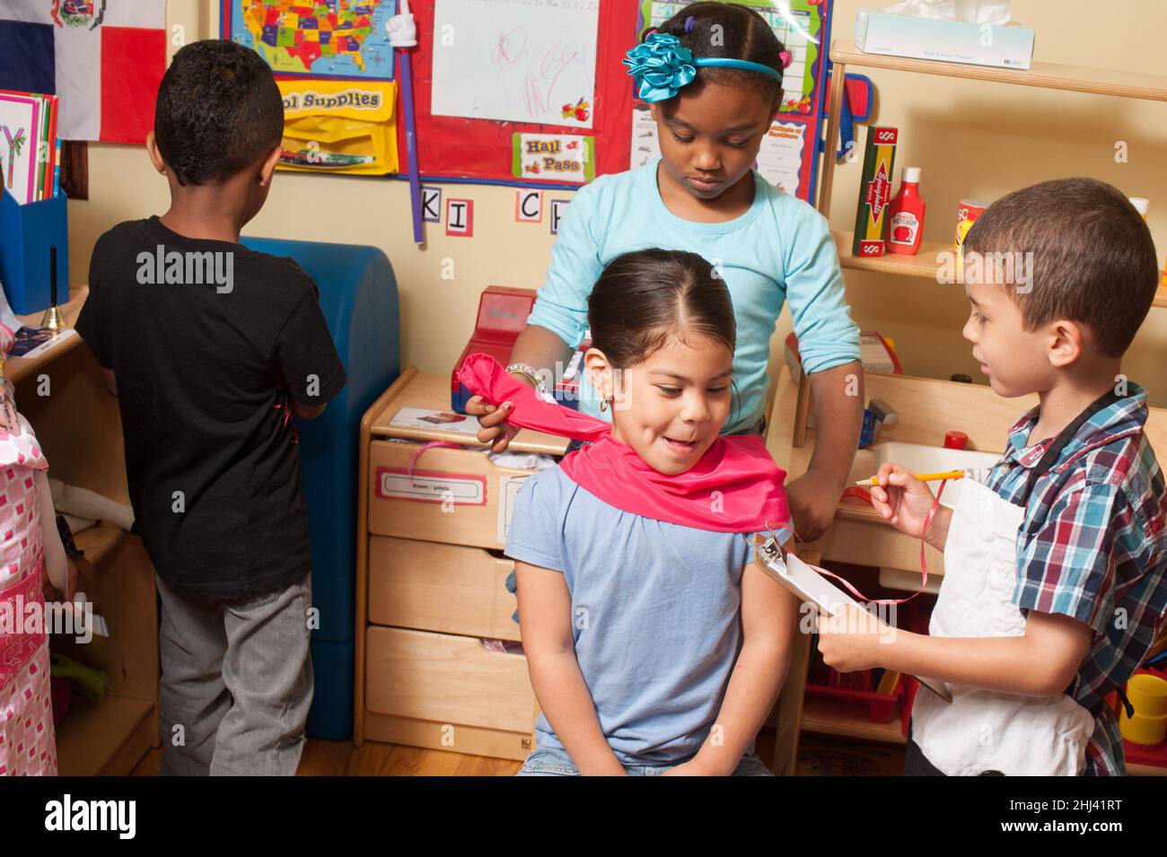 Éducation préscolaire 4 ans prétendre jouer groupe d'enfants jouant jeu fille obtenant coupe de cheveux commander la nourriture du chef Banque D'Images