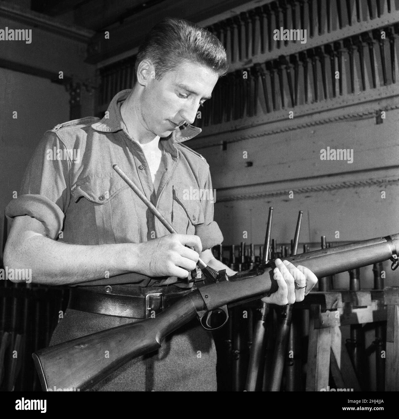 Le footballeur international de Swansea Town et Wales Cliff Jones au service de son service national au sein du régiment d'artillerie royale de la troupe des rois de l'armée britannique. Ici, il nettoie son fusil pour inspection à la caserne de St John's Wood.14th octobre 1957. Banque D'Images