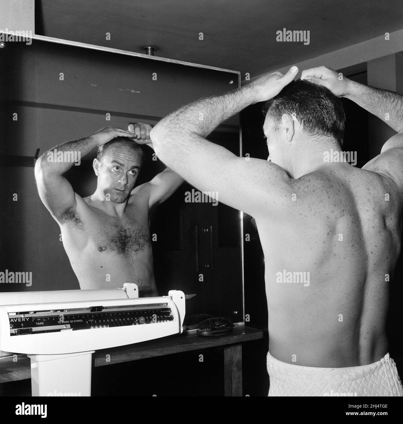 L'équipe de football espagnole s'entraîne au stade du Club de la Banque d'Angleterre à Roehampton.Les hommes ont encerclé le sol plusieurs fois en faisant ce qui est appelé «formation libre».En photo, Alfredo Di Stefano peignant ses cheveux, regardant dans un miroir.25th octobre 1960. Banque D'Images