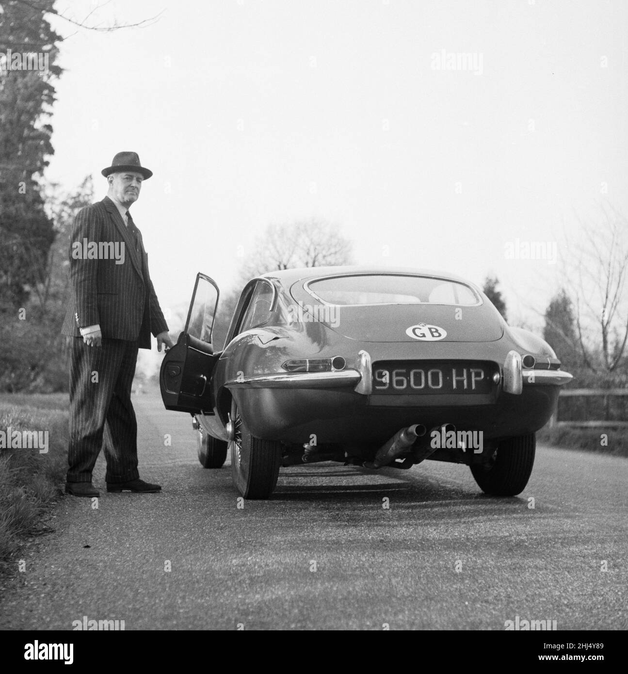 Le correspondant de course automobile du Daily Herald Thomas H Wisdom debout à côté d'une nouvelle Jaguar.13th mars 1961. Banque D'Images